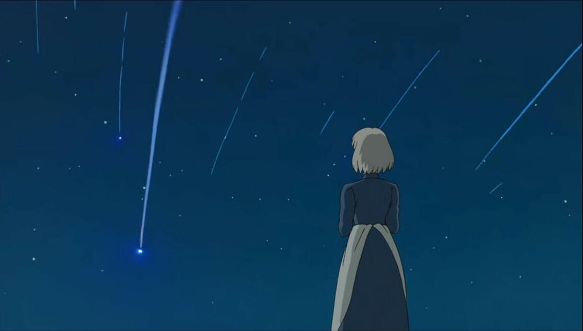 Yet another screenshot from Howl's Moving Castle. Sophie's back is to the viewer; she watches the demons fall as shooting stars.