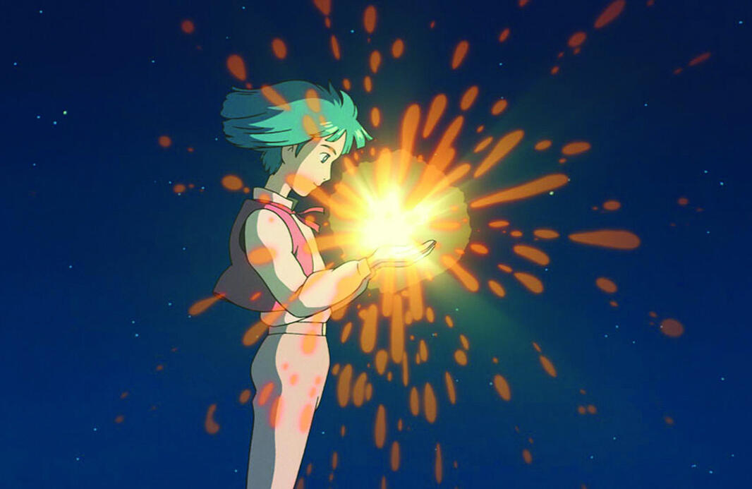 A screenshot from Howl's Moving Castle. Young Howl prepares to swallow Calcifer, who sparks golden and yellow in his hands.